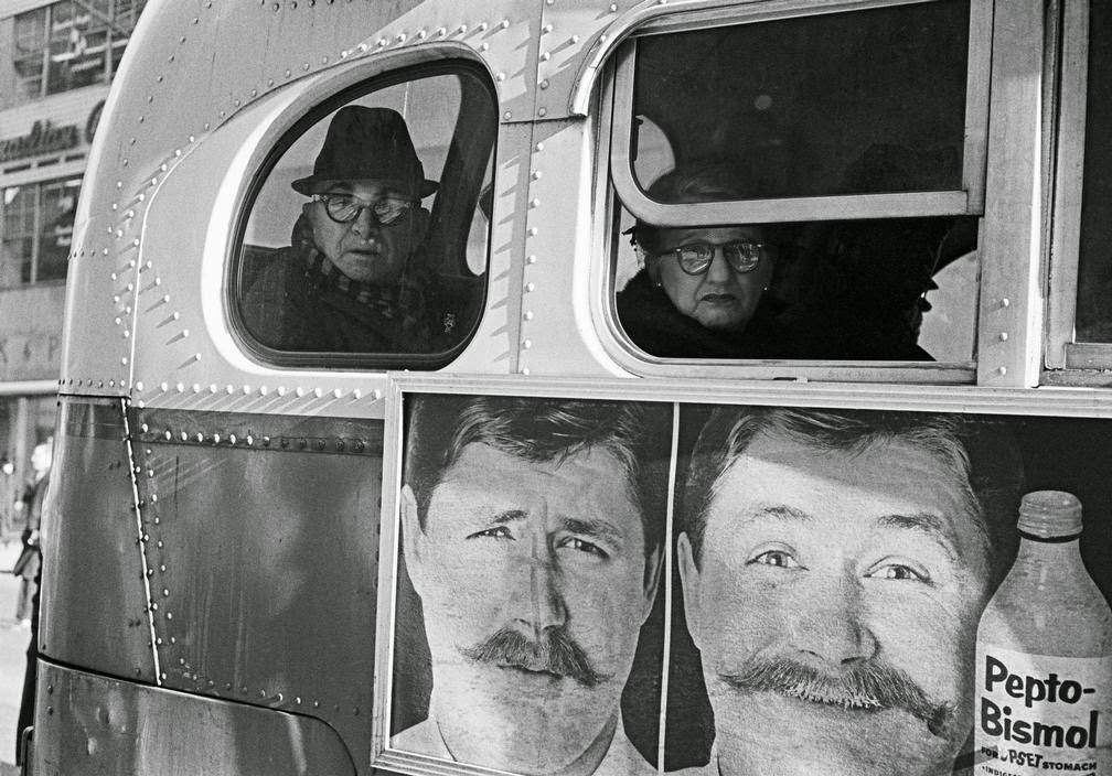 Billboard and passengers on a bus in New York City, 1963