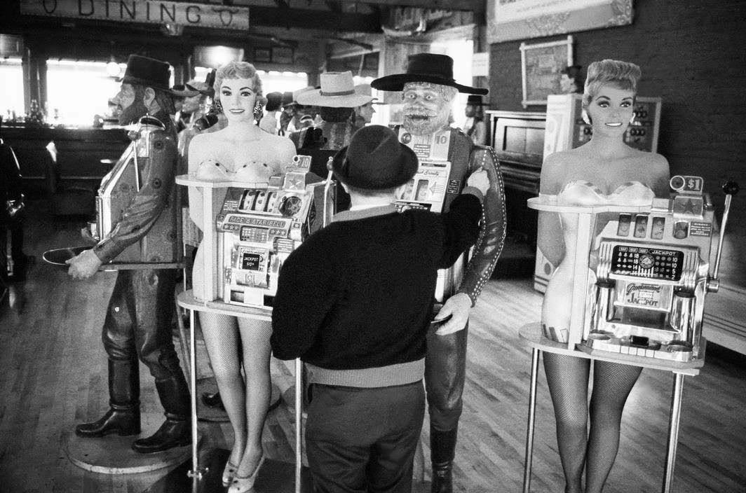 Man in a gaming saloon with slot machines in Virginia City, Nevada, 1963