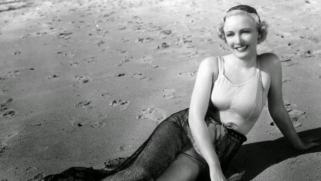 Ann Evors posing for cameramen on the beach, 1928