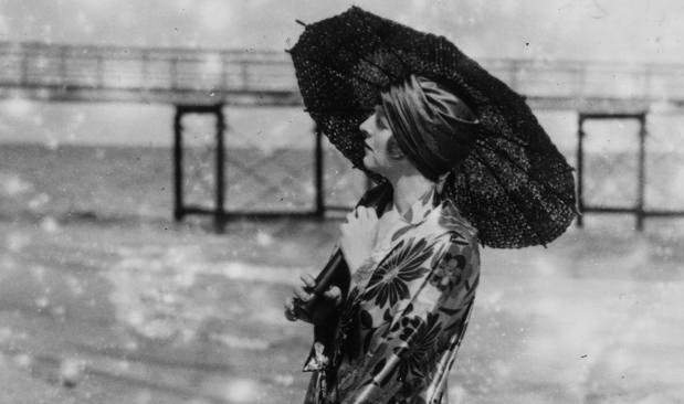 Beach fashion featuring a parasol in England, 1927