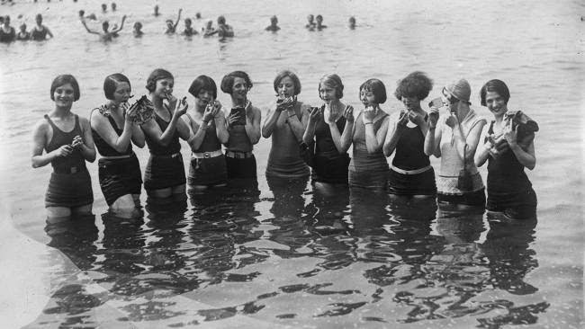 Bathing girls applying makeup in England, 1925