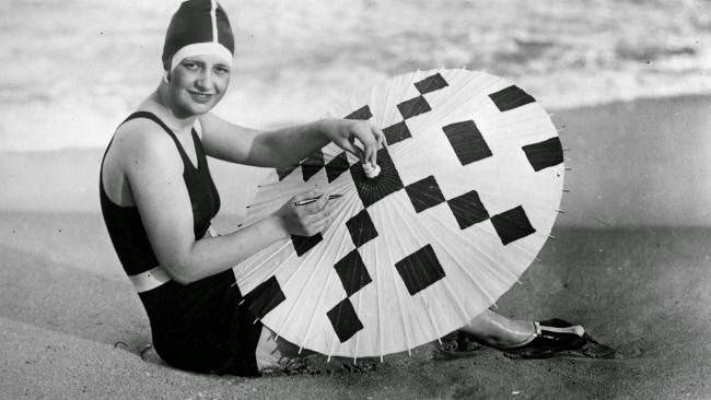 Model creating a crossword design on her beach parasol in Palm Beach, Florida, 1925
