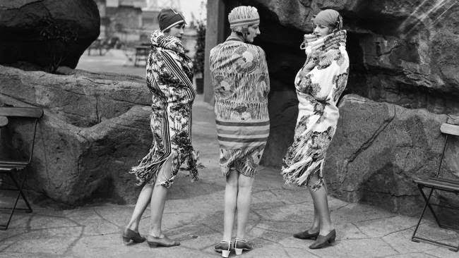 Models wearing beach wraps and bathing hats on a rooftop in London, 1928