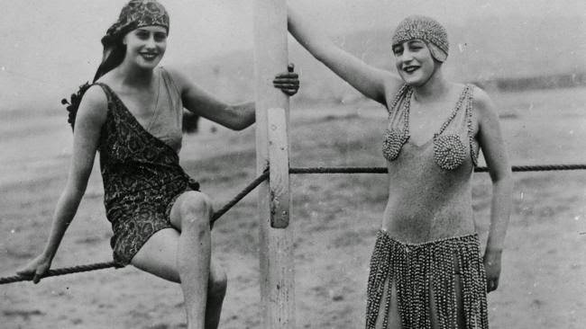Two women modeling bathing suits on the beach at Deauville, 1926