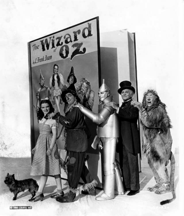 Judy Garland, Ray Bolger, Jack Haley, Frank Morgan, Bert Lahr, and Terry with a prop book, The Wizard of Oz, 1939