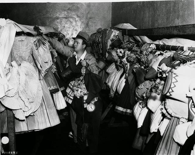 Actor hanging up a Munchkin costume, The Wizard of Oz, 1939