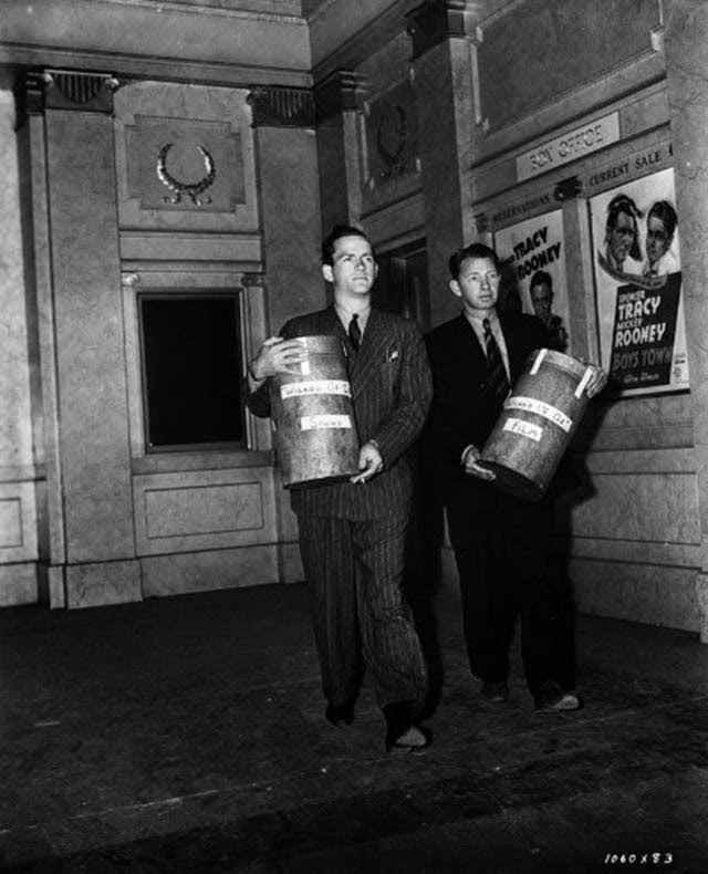 Men carrying sound and visual tracks for a film preview, The Wizard of Oz, 1939