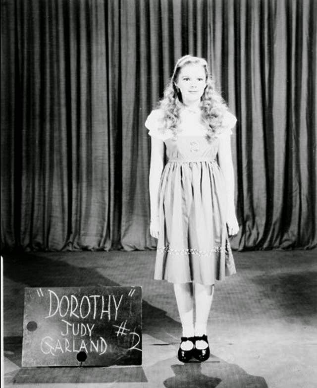 Wardrobe test shot of Judy Garland in a rejected Dorothy costume and blonde wig, The Wizard of Oz, 1939