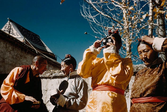 Top Tibetan officials marvel at a souvenir from America. A finance secretary peers through a slide viewer, memento of a Tibetan trade delegation's mission to the United States in 1948.