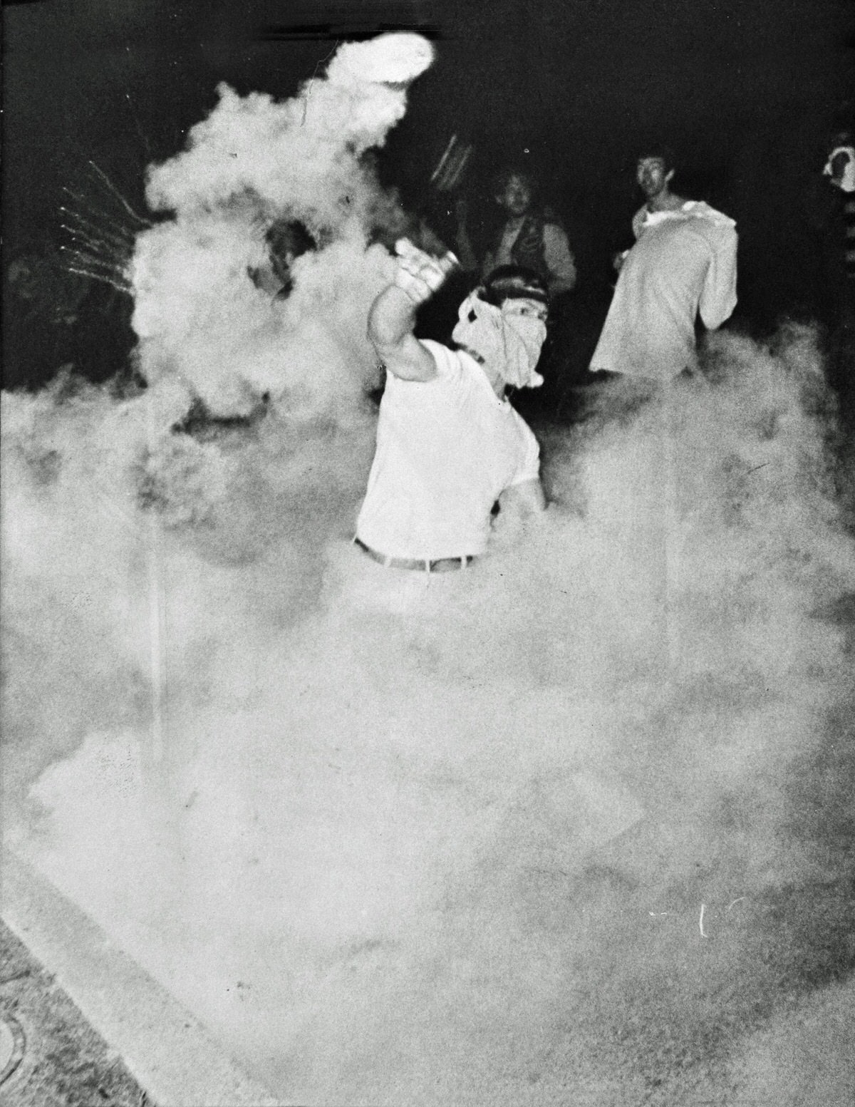 A student tosses a tear gas canister back at police lines during the fiercest fighting with police and National Guard at the University of Maryland on May 14, 1970.