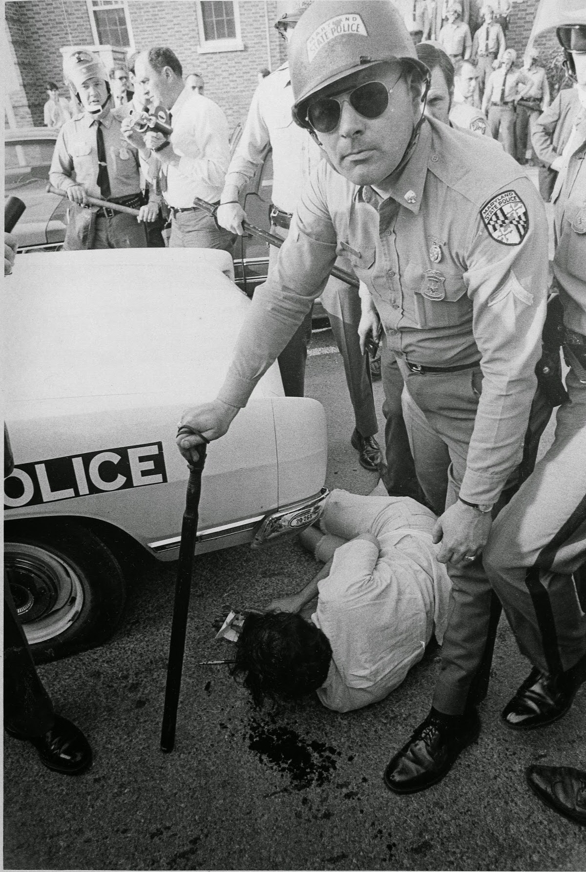 Student arrested after being beaten by state police on campus of University of Maryland during an antiwar demonstration May 1, 1970. Note blood on the street. The demonstration was in response to President Nixon's invasion of Cambodia the day before.