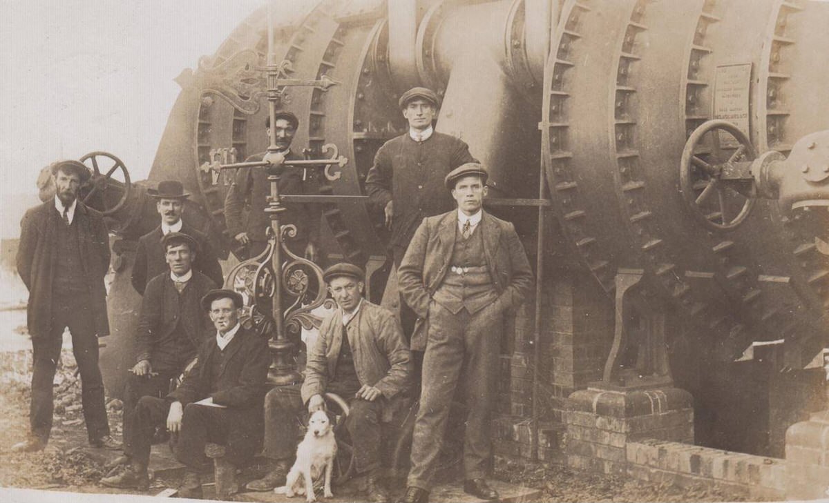 Workers and a dog posing next to machinery at the Powell Duffryn coke ovens in Bargoed, 1910