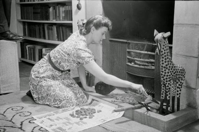 Mrs Day makes her bed in the basement of her South Kensington home before leaving for work. The top floor of her house is no longer in use.