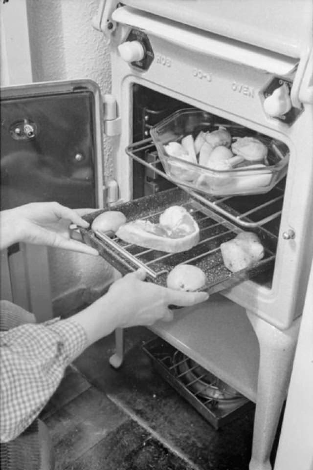 Mrs Day puts her dinner into the oven after a busy day. The Ministry of Food encouraged people to cook their entire meal in the oven as a way to save fuel.
