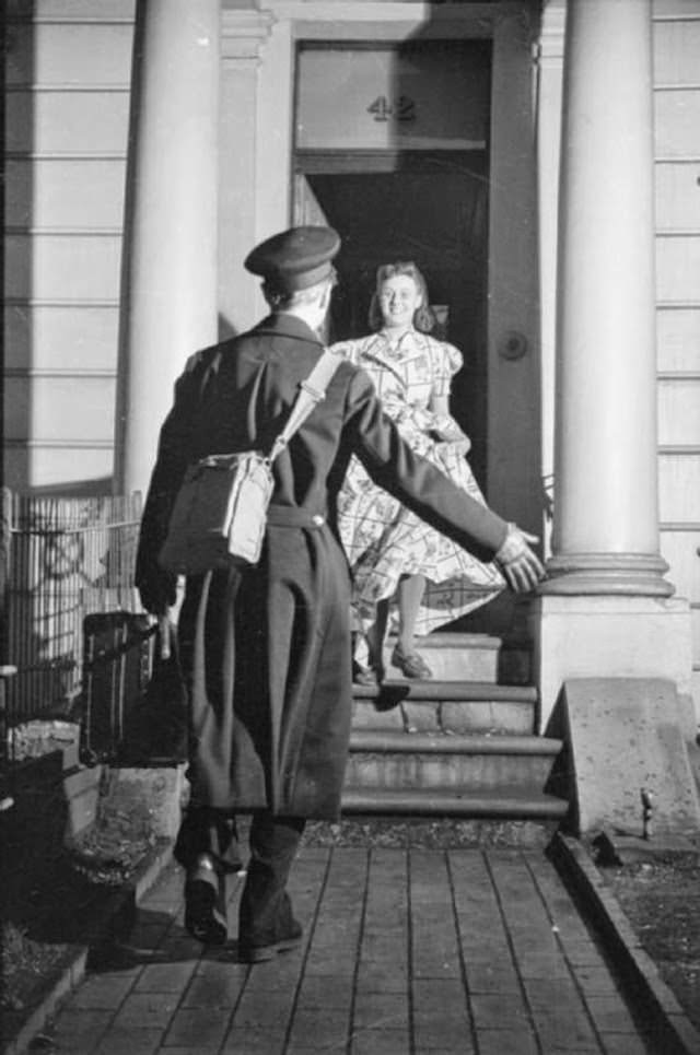 Mrs Day runs to greet her husband Lieutenant Kenneth Day at the door of her South Kensington home as he arrives home on leave.