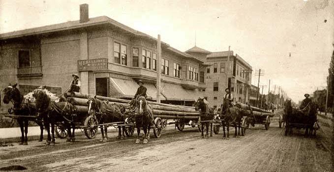 Workers carrying telephone poles, 1910