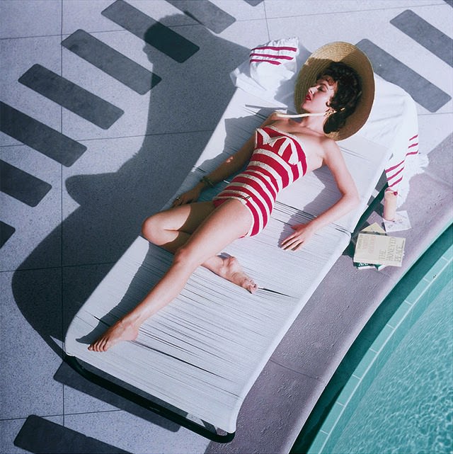 Mara Lane lounging by the pool in a striped bathing costume at the Sands Hotel, Las Vegas, 1954