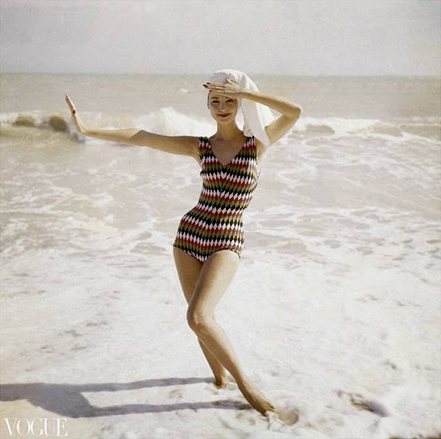 Model on a beach wearing a harlequin-diamond wool bathing suit by Imports International, 1957