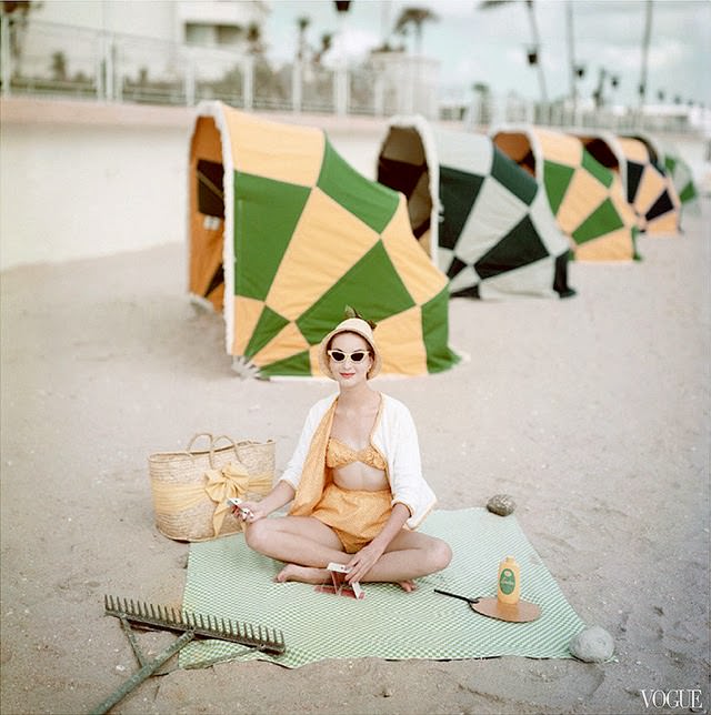 Model on a beach at the Diplomat Hotel, Florida, wearing a calico print swimsuit and terrycloth cardigan, 1959