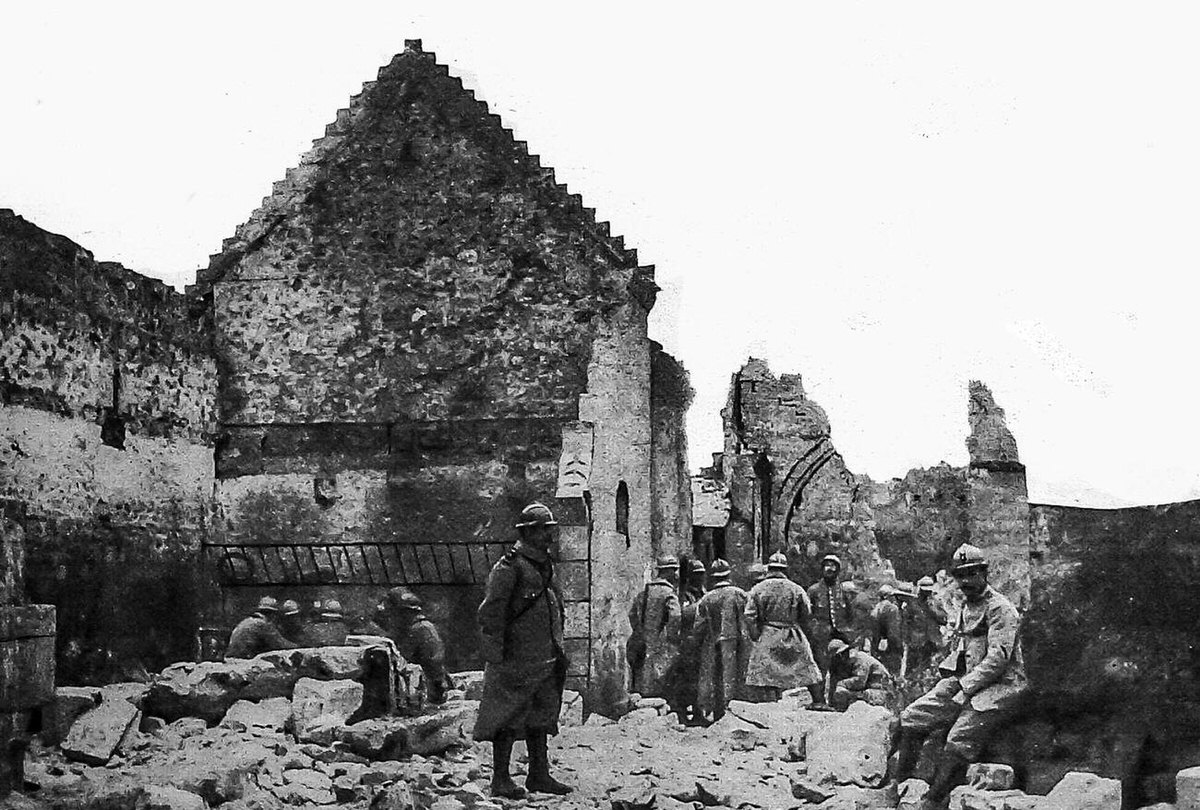 Men standing in the ruins of a building in northeastern France, 1916