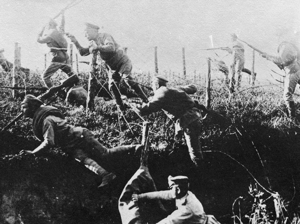 Soldiers moving through a barbed wire entanglement, 1914