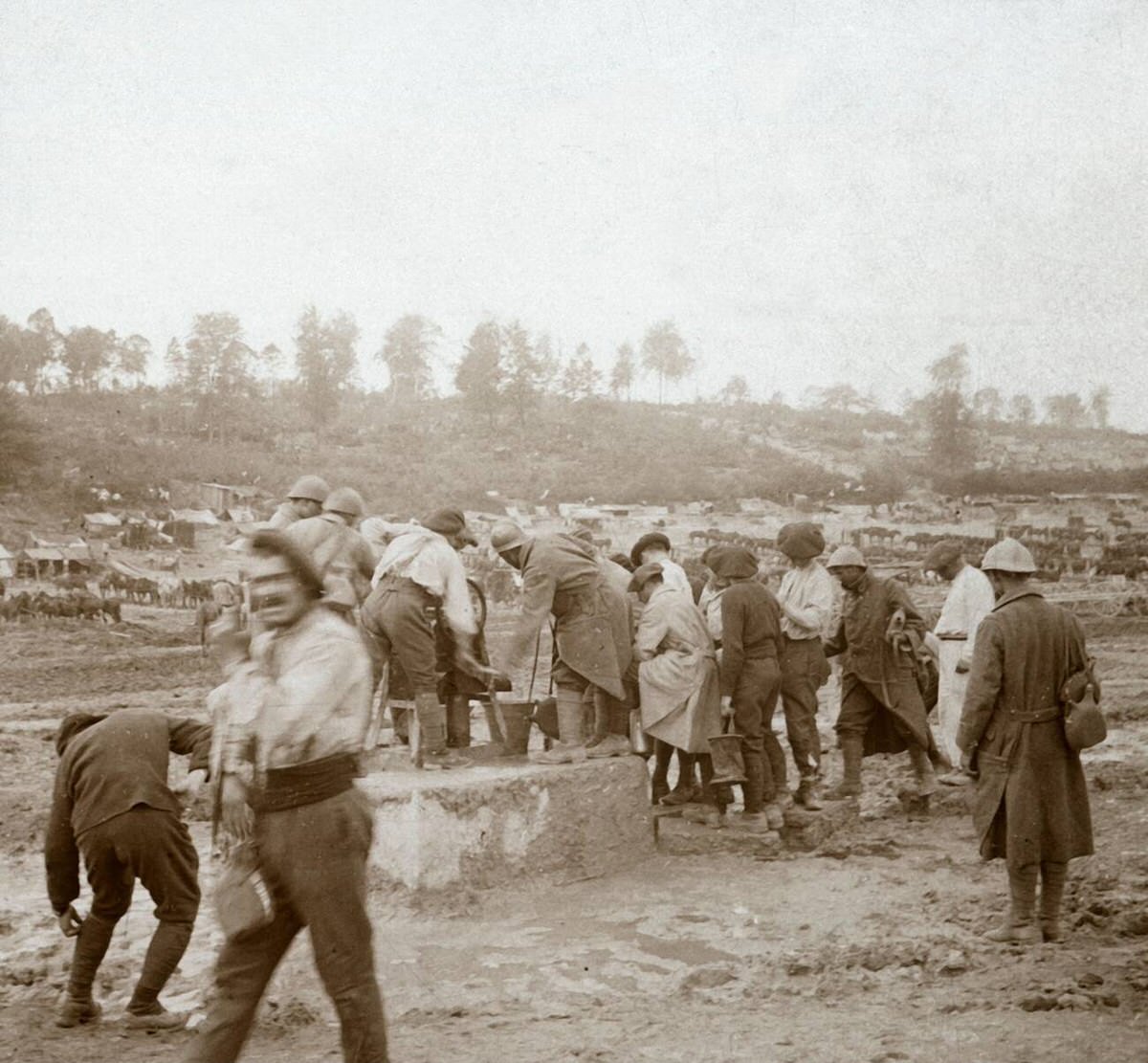 Soldiers queuing in the mud for water in Génicourt, France, 1914