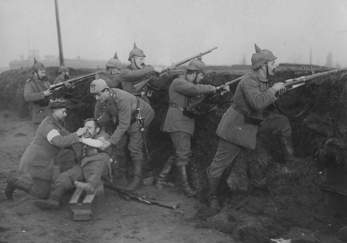 Medic applying a bandage to a wounded soldier on the Belgian coast, 1915