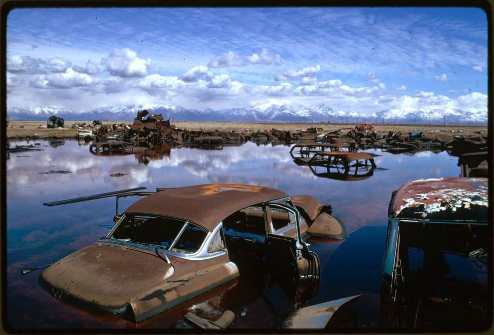 Abandoned automobiles and other debris clutter an acid water and oil filled five acre pond. It was cleaned up under EPA supervision to prevent possible contamination of Great Salt Lake and a wildlife refuge nearby, near Ogden, Utah, 1974
