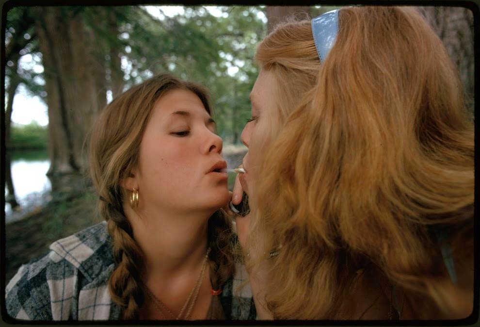 Two girls smoking pot during an outing in Cedar Woods, near Leakey, Texas, 1973