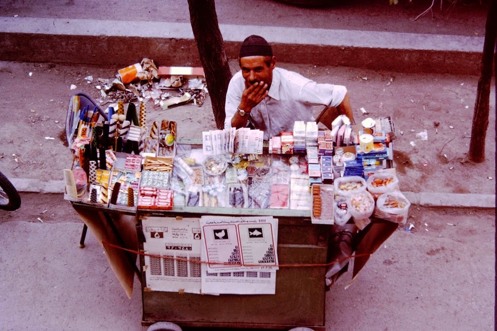A street vendor sells cigarettes, gum, candy and lottery tickets, found on many city streets.