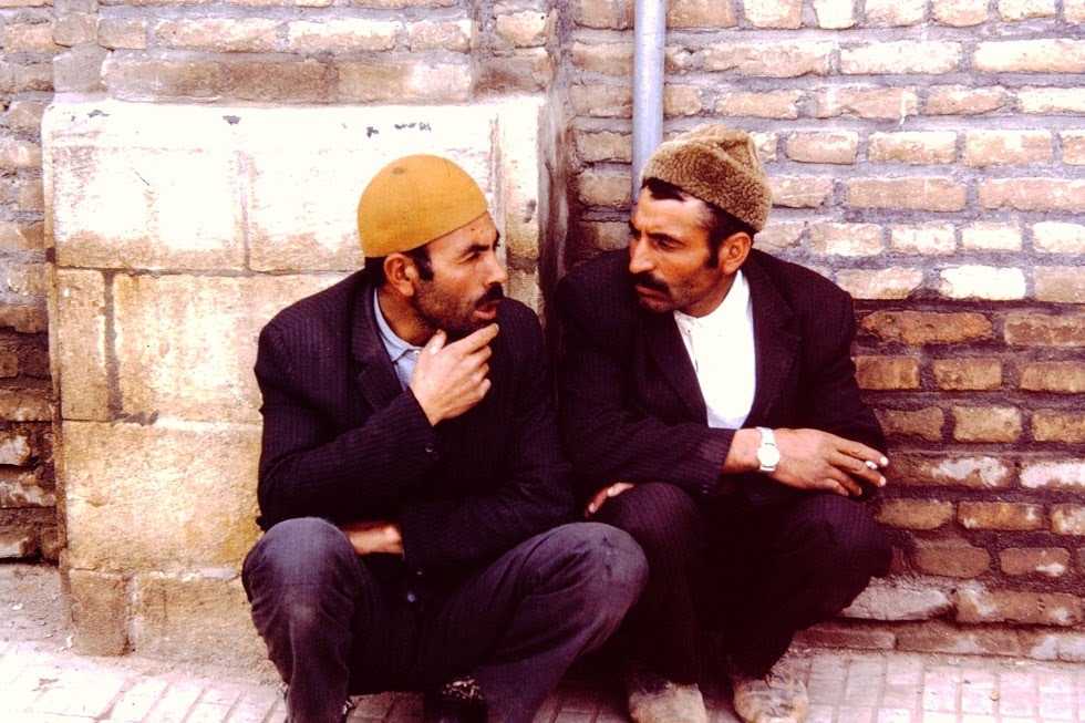 Two guys shooting the breeze, wearing their lamb's wool caps.