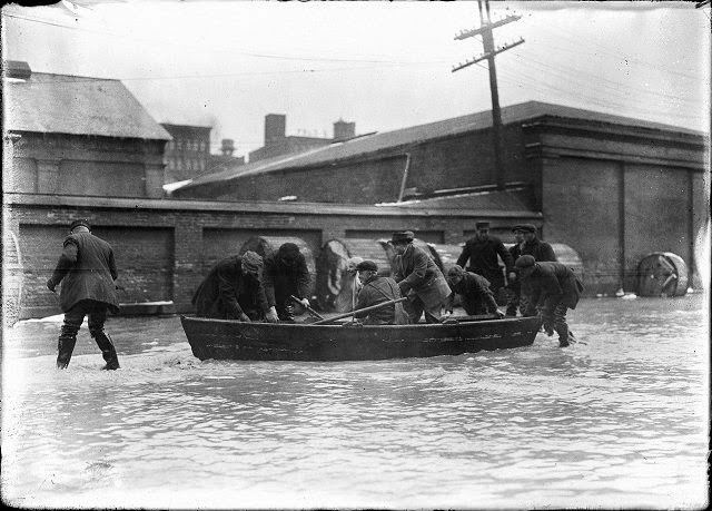 Men in and around a rowboat on Front Street, during the flood, 1913