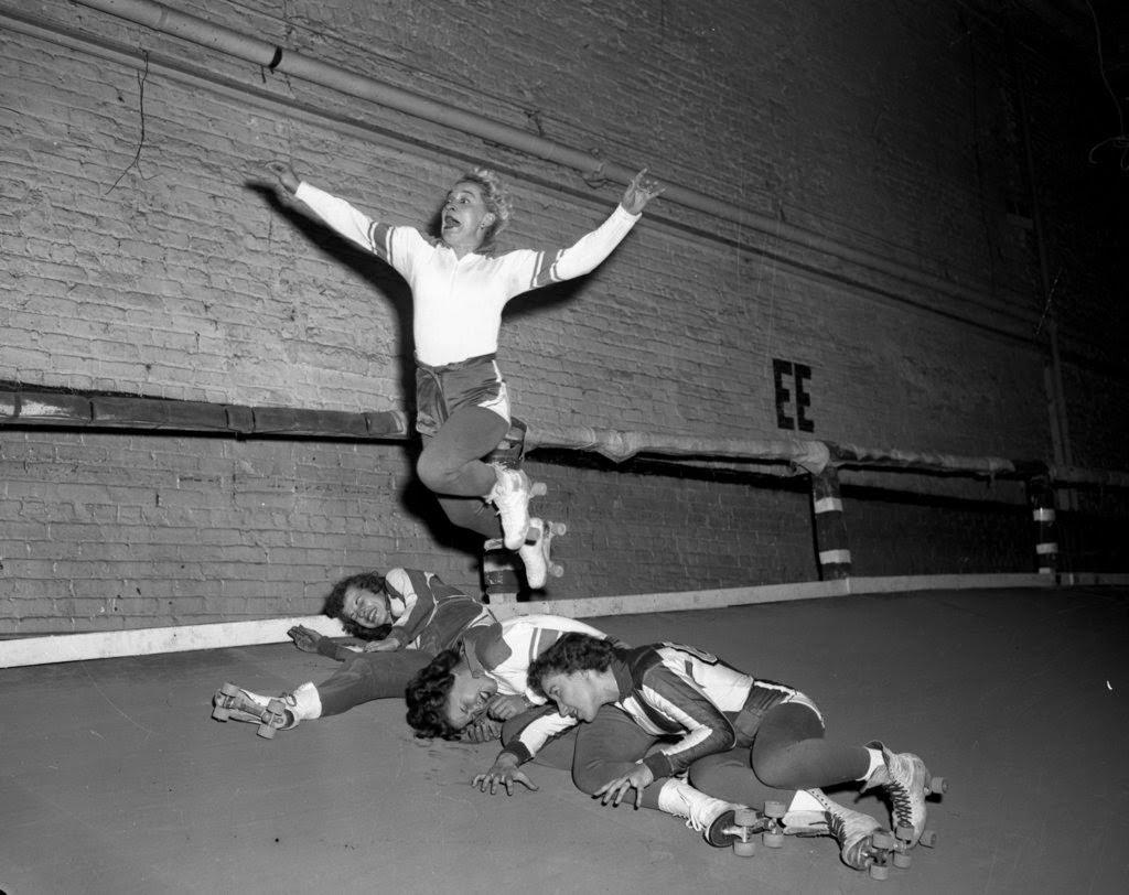 Marjorie Clare “Toughie” Brasuhn flies over Betty Clements, Mary Lou Palermo and Harriette Topel at a roller derby at the Coliseum, 1950s