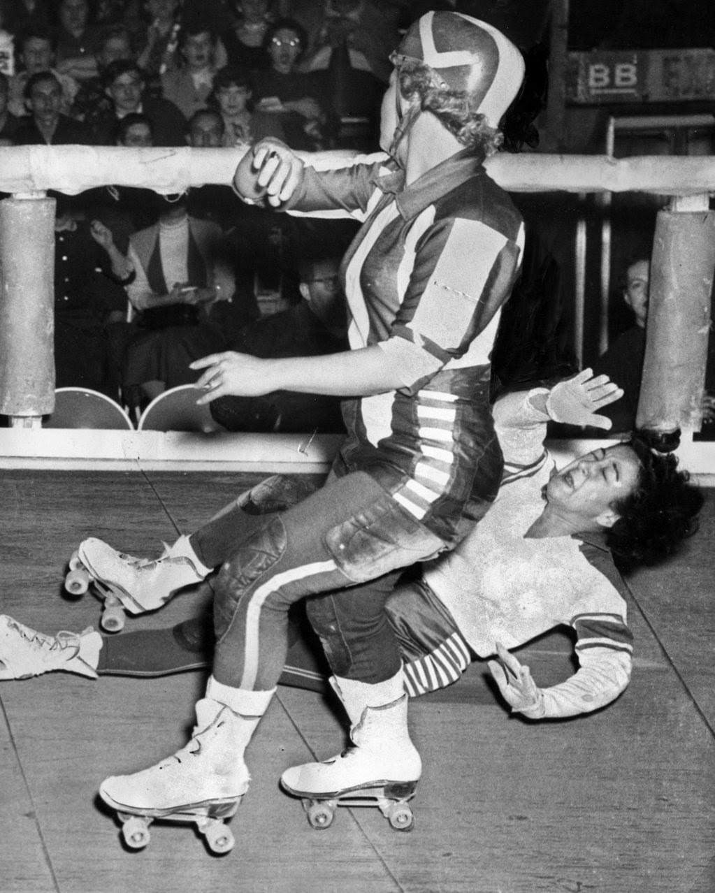 Mary Youpelle of the Chicago Westerners hits the floor after being blocked by Midge “Toughie” Brasuhn of the Brooklyn Red Devils in a roller derby at the Coliseum, 1950s