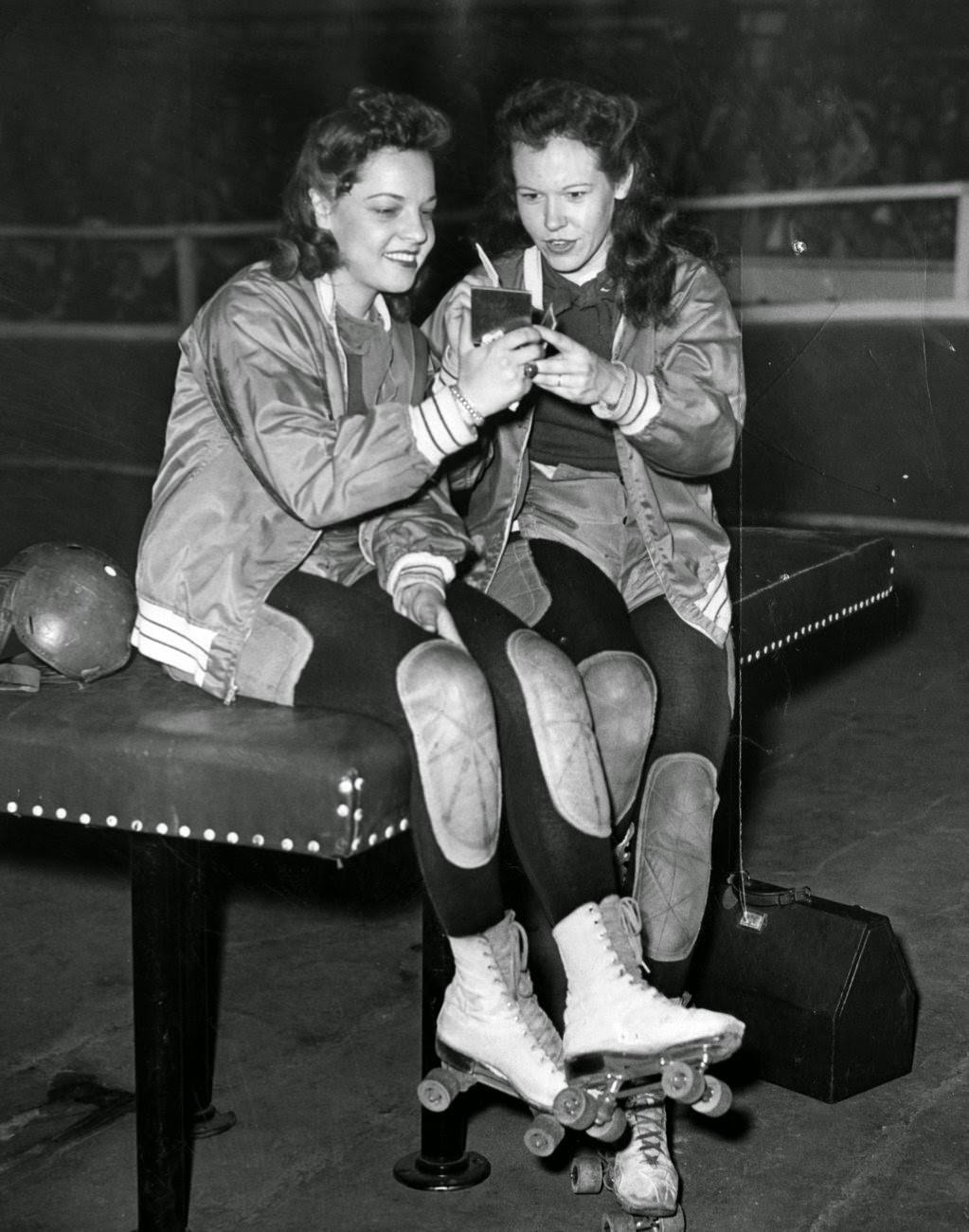 Katy King and Gerry Murray of the Chicago team apply make-up before skating into the roller derby ring, 1940s